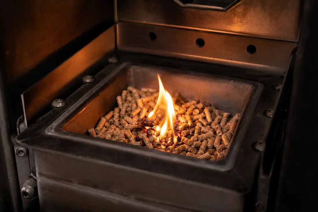 Creuset d'un poêle à pellets rempli de granulés de bois